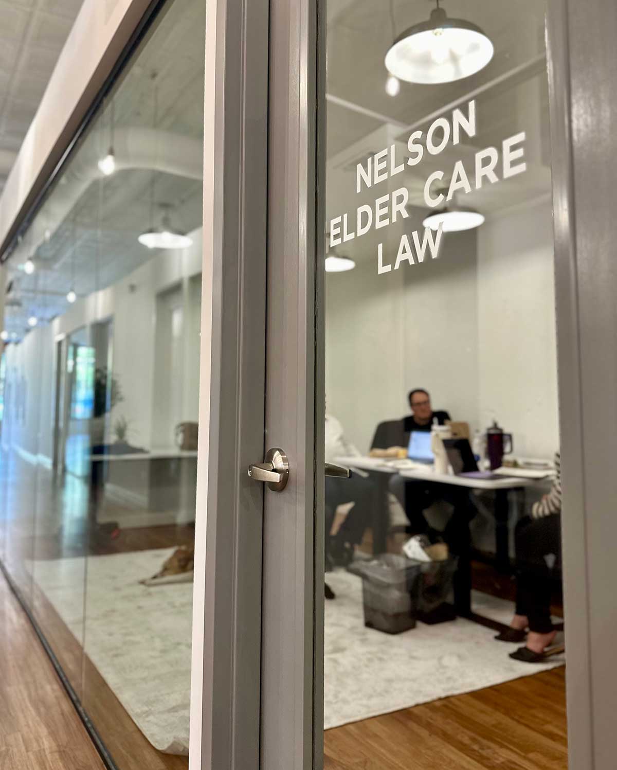 View through the front glass doors into the workspace at Nelson Elder Care Law’s Gainesville office.