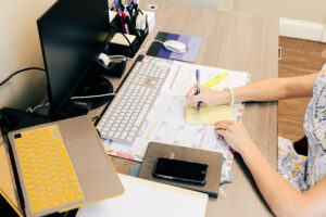 Overhead photo of a desk with a calendar and someone working