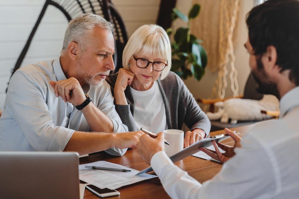 An older couple meets with an attorney to discuss how to protect their assets while qualifying for Medicaid.