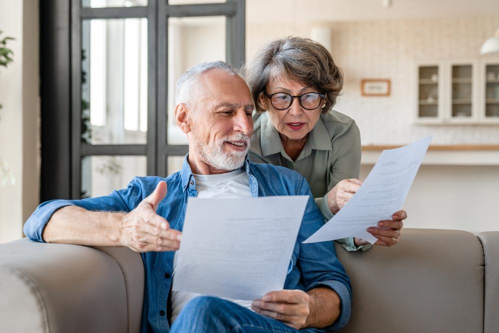 An older couple reviews documents to decide if they should keep their long-term care insurance.